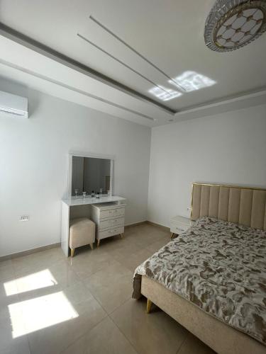 1 dormitorio con cama, tocador y espejo en La maison du Jasmin, en Mahdia
