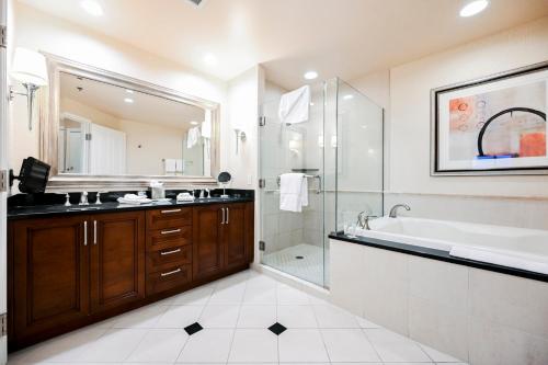 a bathroom with a tub and a sink and a shower at StripViewSuites Penthouse Two-Bedroom Conjoined Suite in Las Vegas