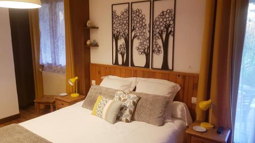 een slaapkamer met een bed met witte lakens en kussens bij "La Coustille" Chambres et Table d'Hôtes in Saint-Léger-les-Mélèzes