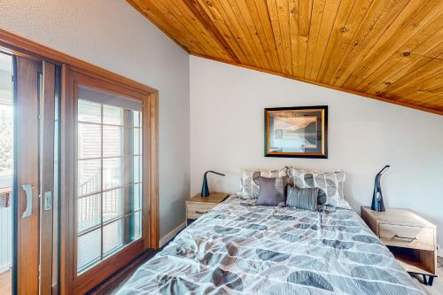 a bedroom with a bed and a wooden ceiling at Singing Winds in Port Orford