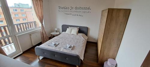 a small bedroom with a bed and a couch at Apartmán Zemplín in Michalovce