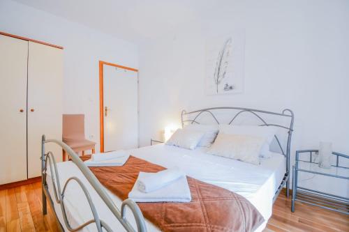 sypialnia z białym łóżkiem z metalową ramą w obiekcie Apartment Anasu w mieście Zadar