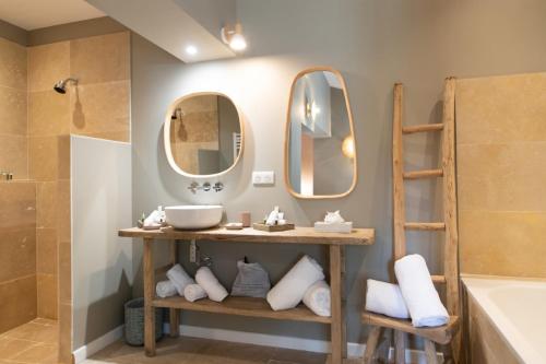 a bathroom with two mirrors and a sink and a tub at La Bastide d'Antoine in Saint-Tropez