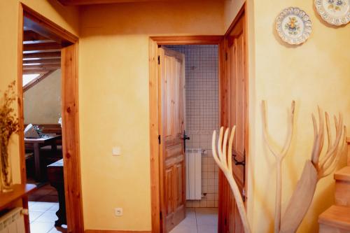 pasillo con puerta a un baño con cuernos en la pared en El Xalet de la Vall de Cardós, en Lladrós