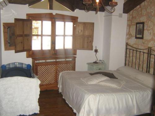 a bedroom with two beds and a window at Hotel Rural Pantano de Burgomillodo in Burgomillodo