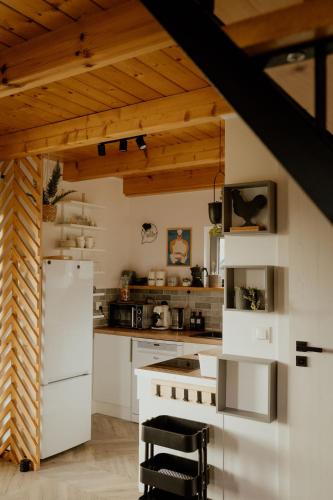 a kitchen with white appliances and a wooden ceiling at Lipa pod groniem in Ustroń