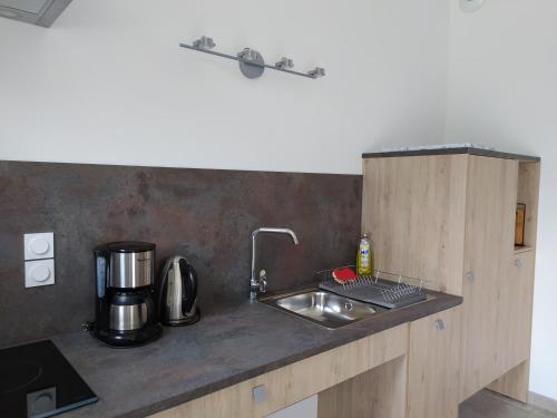 um balcão de cozinha com um lavatório e comodidades para preparar café em Junior Suite Triple PMR Résidentielle avec cuisine au Manoir de Mathan à Crépon 5mn d'Arromanches et 10 mn de Bayeux em Crépon
