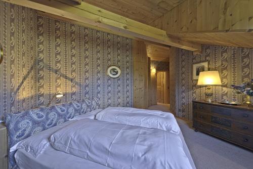 a bedroom with a bed and a wooden wall at Chesa Pradash 5 - Celerina in Celerina