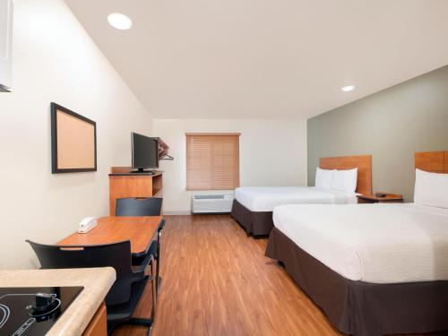 a hotel room with two beds and a desk at Extended Stay America Select Suites - Atlanta - Chamblee in Atlanta