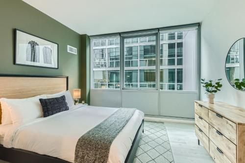 1 dormitorio con 1 cama grande y ventanas grandes en Sentral Michigan Avenue, en Chicago