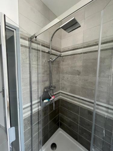 uma casa de banho com chuveiro e cabeça de chuveiro em Maison chaleureuse avec terrasse privative proche de la gare em Rochefort