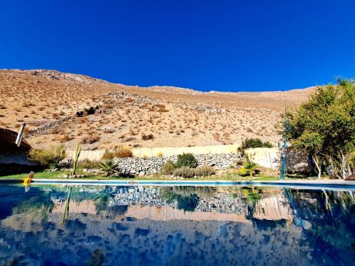 a pool of water with a mountain in the background at Reset Elqui in Alcoguaz