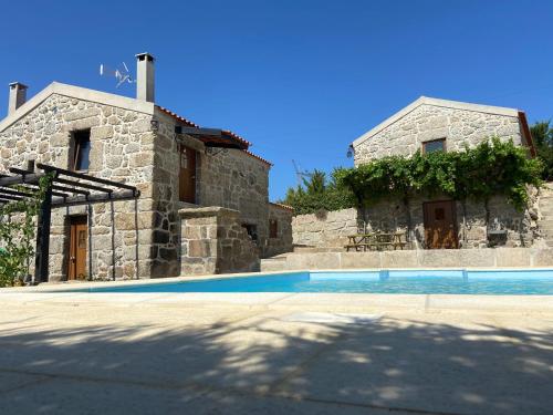 a house with a swimming pool in front of it at Quinta da Cortelhinha Turismo Rural in Oliveira do Hospital