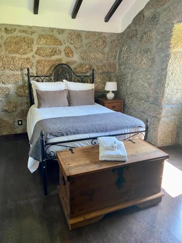 a bedroom with a bed and a wooden table at Quinta da Cortelhinha Turismo Rural in Oliveira do Hospital