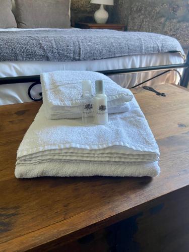 two towels and two bottles of soap on a wooden table at Quinta da Cortelhinha Turismo Rural in Oliveira do Hospital
