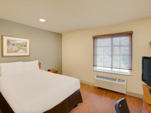 a bedroom with a white bed and a window at Extended Stay America Select Suites - Shreveport - Airport in Shreveport