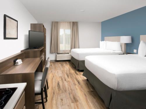 Extended Stay America Suites - Boston - Saugus في سوجس: غرفة فندقية بسريرين ومكتب