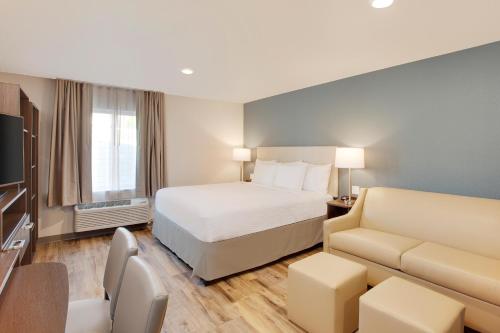 a hotel room with a bed and a couch at Extended Stay America Suites - Boston - Saugus in Saugus