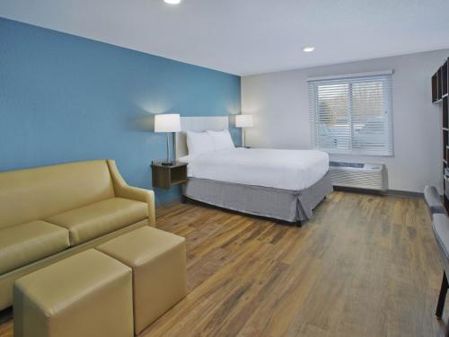 a hotel room with a bed and a couch at Extended Stay America Suites - Detroit - Rochester Hills in Rochester Hills