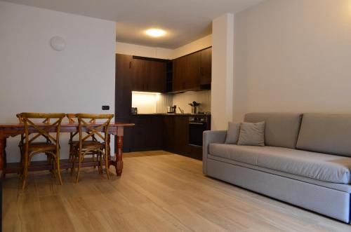 a living room with a couch and a table and a kitchen at Appartamenti Sky Express in Campodolcino