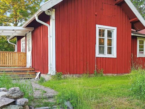 een rood huis met een wit raam en een veranda bij 6 person holiday home in BJ RKVIK in Björkvik