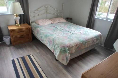 1 dormitorio con 1 cama y mesita de noche con lámpara en 2 Bedroom Condo in Rehoboth Beach w/ New Bed, en Rehoboth Beach