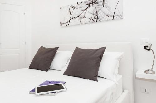 a bed with pillows and a book on it at White Flat Colosseo in Rome