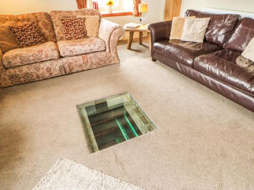 a living room with a couch and a glass floor at Low Shipley Mill in Barnard Castle