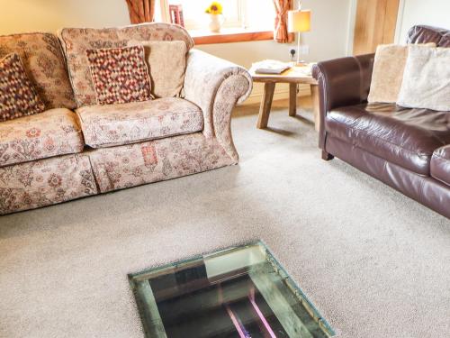 a living room with a couch and a glass table at Low Shipley Mill in Barnard Castle
