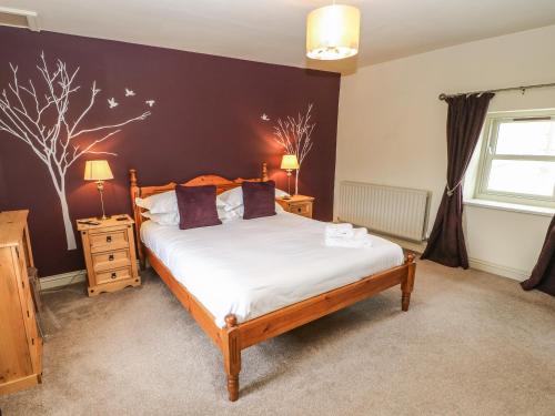 a bedroom with a bed and two night stands with lamps at Low Shipley Mill in Barnard Castle