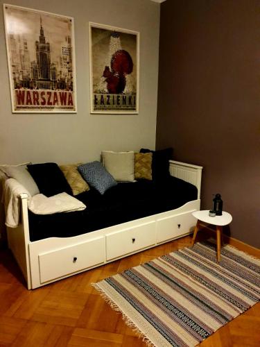 a bed in a living room with a black and white at Vistula studio in Warsaw