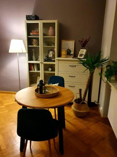 a table and chairs in a room with a dresser at Vistula studio in Warsaw