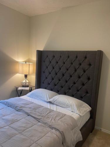 a bedroom with a large bed with a black headboard at N-E-G House - near DAVID WAYNE HOOKS Airport in Houston
