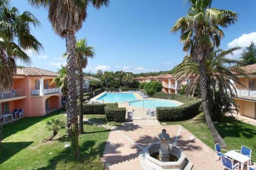 格里莫的住宿－Appartement La Palmeraie Odalys Prestige Grimaud，享有度假村的空中景致,设有游泳池和棕榈树