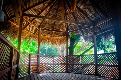 Habitación grande con techo de paja y ventana grande. en POUSADA IPIRÃTÃ - Turismo de Vivência Cultural en Soure