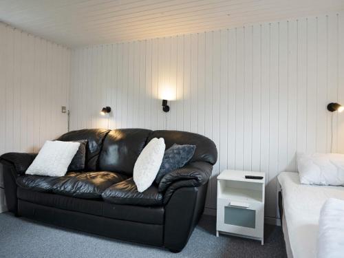 霍爾拜克的住宿－Holiday home Holbæk XV，一张黑色皮沙发,位于带床的房间