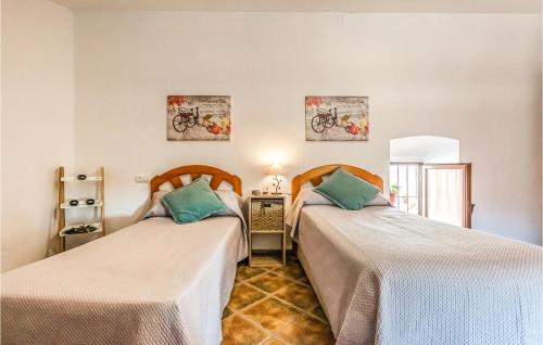 a room with two beds and a table at Pet Friendly Home In Hornachuelos With Kitchen in Hornachuelos