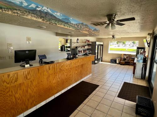 a bar in a restaurant with a counter with a tv at Rodeway Inn - SFI Winnemucca in Winnemucca