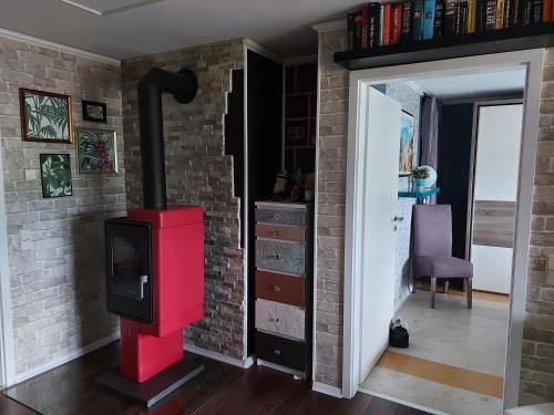 a red stove in a room with a brick wall at Im Erzgebirge Wandern, Fahrrad fahren oder entspannen in Ehrenfriedersdorf