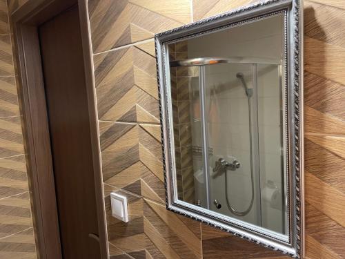 La salle de bains est pourvue d'un miroir et d'une douche. dans l'établissement Kovács Apartmanház, à Kiskunhalas