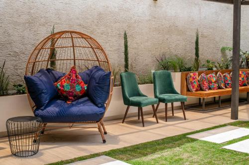 a blue chair and two green chairs and a table at Hotel Las Camelias Inn by AHS in Antigua Guatemala