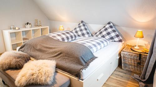 um quarto com uma cama com almofadas em Dachwohnung mit Ofen und Freisitz em Ühlingen-Birkendorf