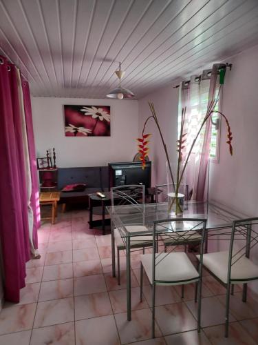 a dining room with a glass table and chairs at Couleurs îsles in Montjoly