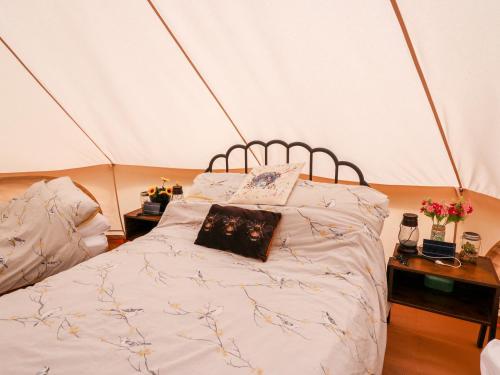 a bedroom with a bed in a tent at Heron's Retreat in Llandysul