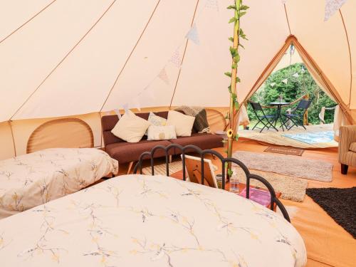 a tent with two chairs and a couch in it at Heron's Retreat in Llandysul