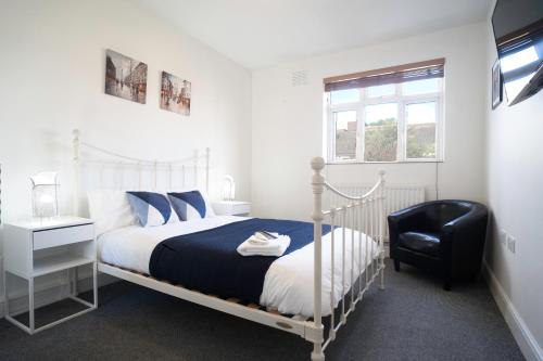 a bedroom with a bed and a black chair at Amazing Apt with 2 bathrooms close to Battersea Park in London
