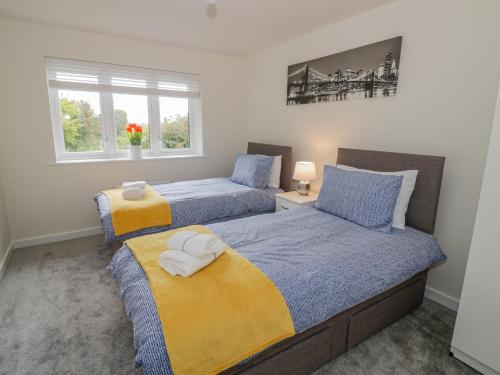 a bedroom with two beds and two windows at 23 Moat House Close in Coventry