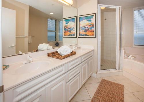 a white bathroom with a tub and a sink at Beach Colony East 12C in Pensacola