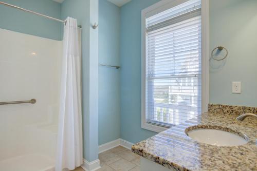uma casa de banho com um lavatório e uma janela em Seafoam Serenity Ocean Ridge em North Topsail Beach
