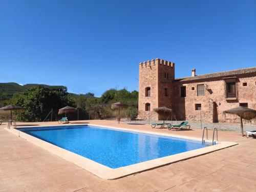 a swimming pool in front of a building at MASÍA de SAN JUAN CASA NÚMERO 1 en Castillo con piscina y Aire Acondicionado in Segorbe